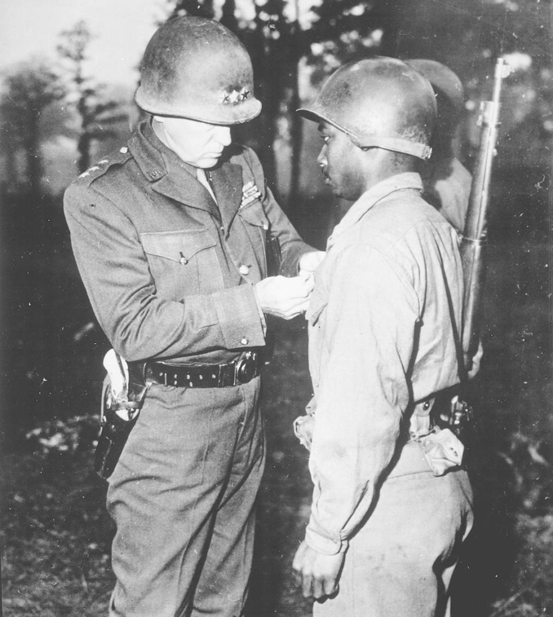 General George S. Patton, U.S. Third Army commander, pinning the Silver Star on Private Ernest A. Jenkins of New York City for his conspicuous gallantry in the liberation of Chateaudun, France, 1944. (Credit: The National Archives)